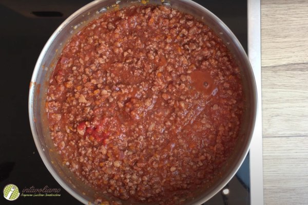 preparazione del ragu alla bolognese, fase dell'aggiunta del sugo di pomodoro